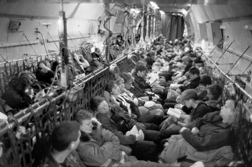 <p>In an Air Force C-141, 132 scientists and support staff make the 5 1/2 hour flight from New Zealand to McMurdo Station. Dressed in "extreme cold weather" gear, the women are seated in front so they can use the crew facilities under the flight deck. Men are in back so they can use the funnel behind the curtain.</p><p>&ldquo;Just as the plane touched down you could look at all the people and see the excitement in their faces. I thought, &lsquo;finally I&rsquo;m getting to a continent before my father&rsquo;.&rdquo;<br/>—Anna Meade, hazardous waste specialist</p><p>&ldquo;As soon as I heard about the place I wanted to come. But I didn&rsquo;t want to know anything about it on the off chance that I wouldn&rsquo;t make it here. It would be worse to know how amazing it was and not come. I&rsquo;ve got a huge collection of books now.&rdquo;</br>—Dr. Simon Hart</p>