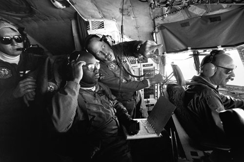 <p>The crew confers on the flight deck of a LC-130 en route to the South Pole Station in one of the season&rsquo;s 146 scheduled flights.</p><p>"Our morale here is typically pretty high because we&rsquo;re all so close together, more like a family unit. We are very disappointed that the Navy has decided after 40 years in Antarctica to withdraw. It&rsquo;s a real strong tradition here. For the most part the flights to the pole are seen as routine flights by the crew. To them it&rsquo;s just another flight. In fact, we have a saying, &rsquo;Rickety rack, to the pole and back&rsquo;."<br/>—Naval Officer Gary Iverson (far left)</p>