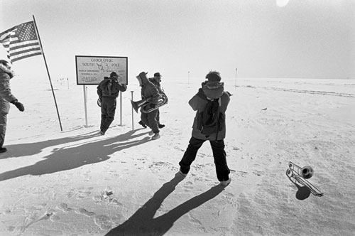 <p>Near Christmas a Navy quintet hitches a ride to the pole to play a quick concert of carols while the plane is unloading. It&rsquo;s a struggle to play wind instruments at that altitude but they really had to see the pole.</p><p>"We are on deck at the pole for 45 minutes or an hour. Sometimes we carry a box of flags. We pull out each flag and hold it over the pole a couple seconds, just long enough to let the winds blow through them. These are flown back to the States and are presented to people at ceremonies as &rsquo;flags that have flown over the South Pole."<br/>—Naval Officer Gary Iverson</p>