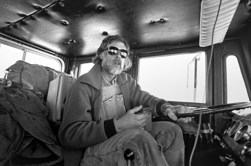 <p>John Wright, leader of a truck convoy, makes a "traverse" over the sea ice 60 miles from McMurdo Station to Marble Point.</p><p>"We come in on Winfly in late August and look at the cracks in the ice and lay out the best routes we can. Then we mark it with flags and program the route on our GPS units. We often get into bad weather out here. Sometimes we don&rsquo;t even bother to clear the windshields. We just follow the GPS and watch the flags go by."<br/>—John Wright</p>